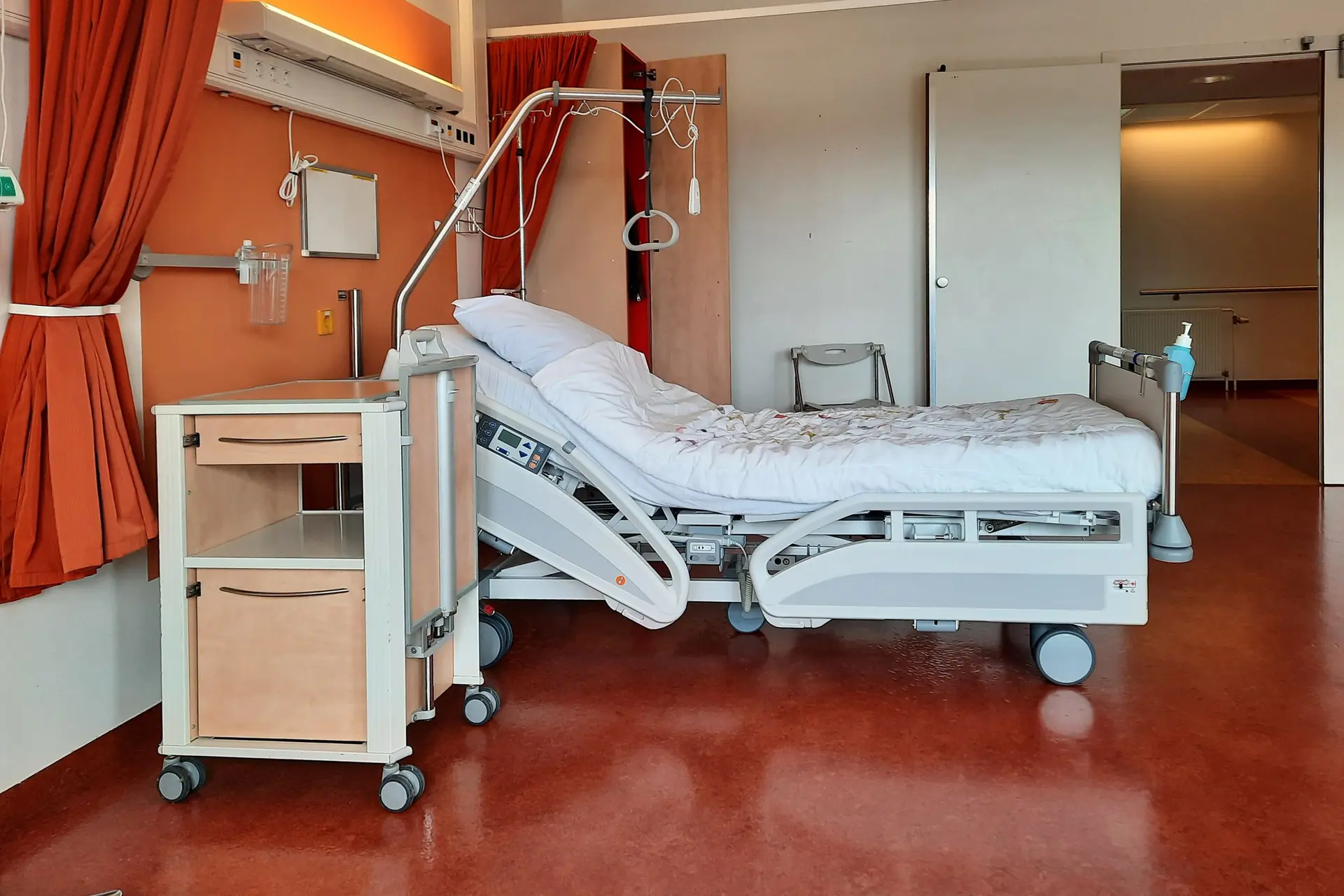 Chambre d'h&ocirc;pital avec lit m&eacute;dicalis&eacute; et table de chevet